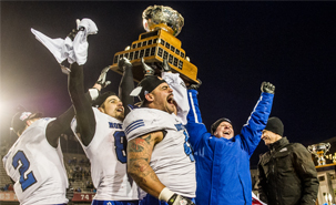 Mikhaïl Davidson (88), Byron Archambault (41) et l'entraîneur-chef Danny Maciocia soulèvent la première Coupe Vanier de l'histoire de l'équipe. (Photo : James Hajjar) Les champions