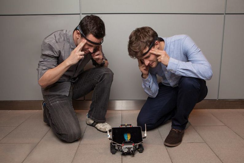 Le robot NeuralDrift, un jeu interactif conçu durant le marathon de programmation WearHacks, est contrôlé par la pensée! Les deux joueurs doivent synchroniser l’activité électrique de leur cerveau à l’aide d’un casque muni d’électrodes pour faire avancer et tourner le robot. Le robot NeuralDrift, un jeu interactif conçu durant le marathon de programmation WearHacks, est contrôlé par la pensée! Les deux joueurs doivent synchroniser l’activité électrique de leur cerveau à l’aide d’un casque muni d’électrodes pour faire avancer et tourner le robot.