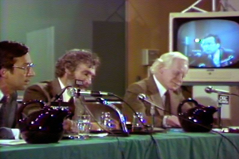 Robert Bourassa (à gauche) défend le Non à quelques semaines du référendum de 1980; Pierre Bourgault (à droite) lui donne la réplique dans un local de l'UdeM. Le débat est animé par René J. A. Lévesque (au centre).