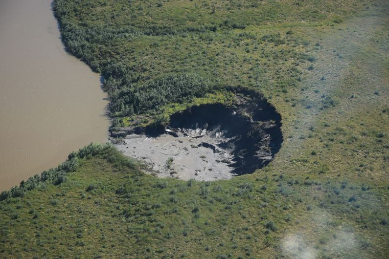 Photo aérienne d'un affaissement de terrain d'un diamètre d'environ 75 mètres attribuable au dégel du pergélisol dans les environs d'Inuvik, dans les Territoires du Nord-Ouest.