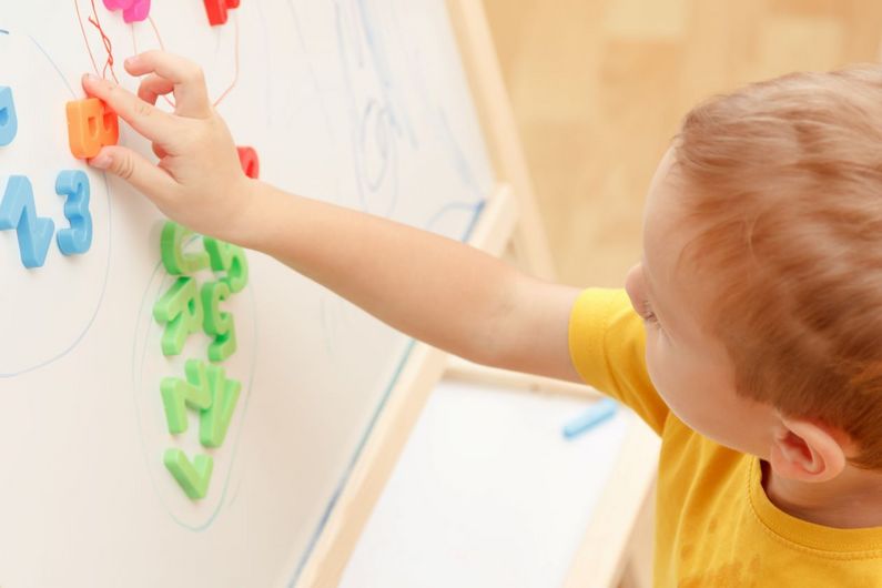 Des enfants qui se dirigent systématiquement vers le tableau magnétique de la salle de jeu pour manipuler les lettres aimantées, ce peut être un indice de leur fascination pour l’écriture.