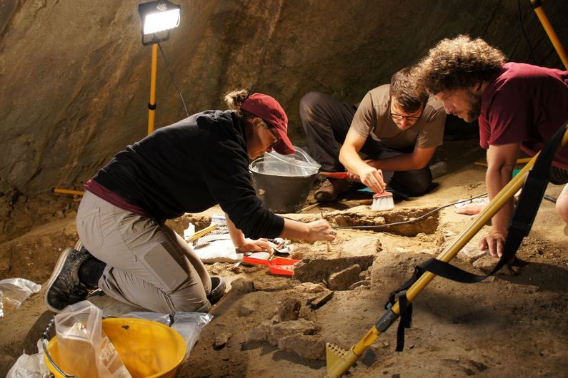 UdeM archaeologist Julien Riel-Salvatore (r) and his doctoral student Geneviève Pothier Bouchard (l) excavating the burial site of baby Neve in the Arma Veirana cave in Liguria, Italy, in 2018; in the background is PhD student Simon Paquin. 