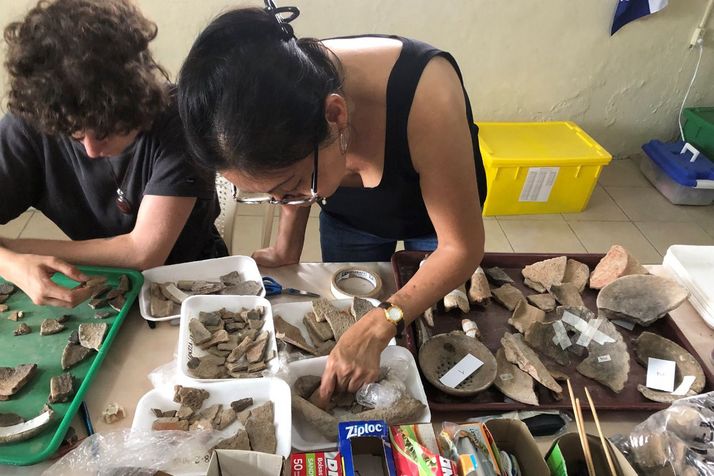 Two students analyze ceramic fragments in the Flores laboratory.