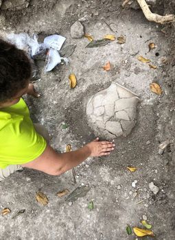 Anthropology student at UdeM, Yasmine Flynn-Arajdal discovers a partially complete olla (Mayan pot) in a residential group in Ucanal.