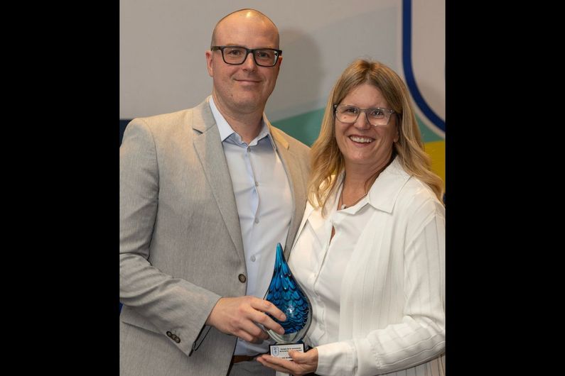 Francis Ménard, directeur général de la Fédération de natation du Québec, remet à Manon Simard, directrice générale du CEPSUM, le prix Hommage posthume à Gilles Durocher pour son rôle de bâtisseur au sein de la Fédération.