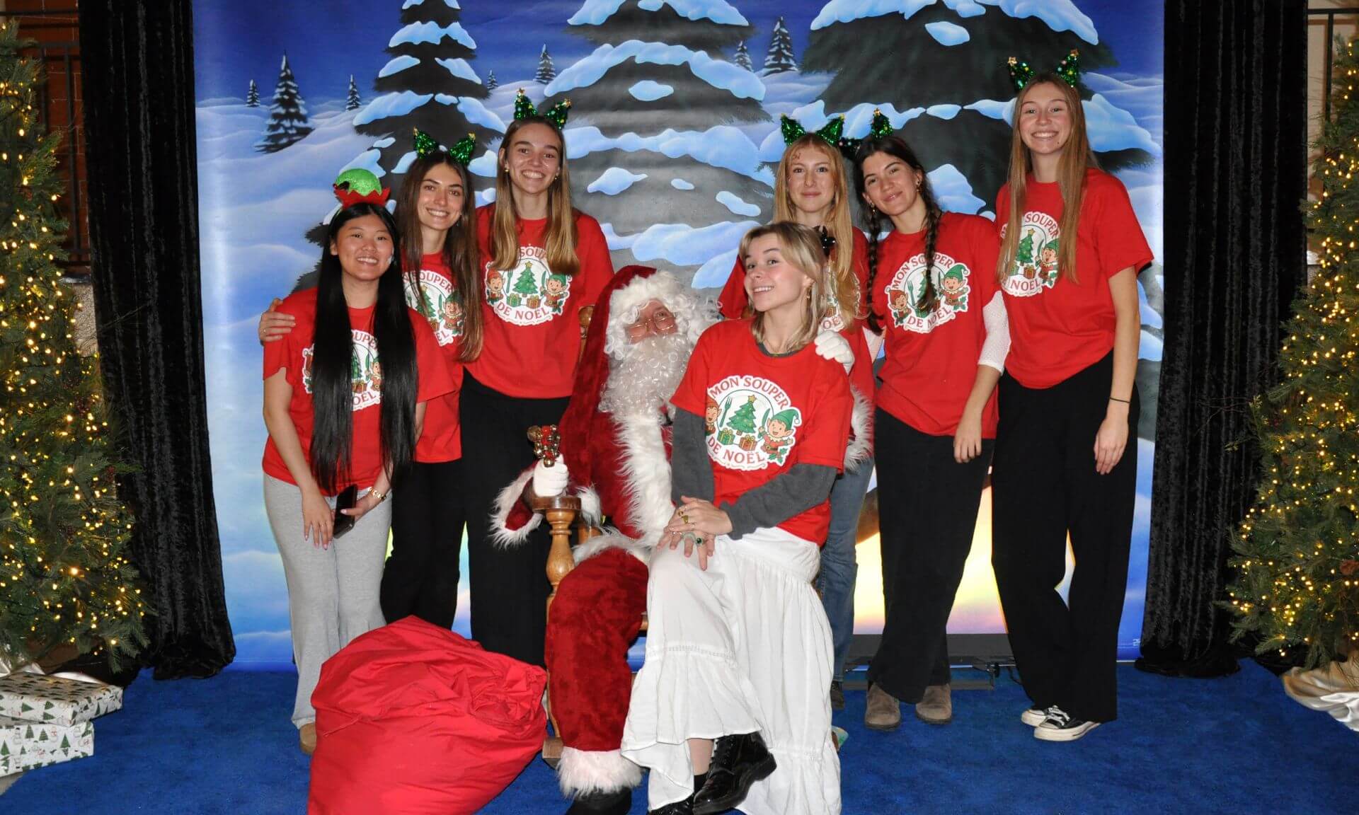 Les six organisatrices (de gauche à droite, Lara Tu-Tam Nguyen, Florence Emard, Laurie-Anne Lalonde, Coralie Marier, Léanne Poignonnec et Marianne Larose) et la bénévole Maë Beaucage avec le père Noël, présent lors du souper.