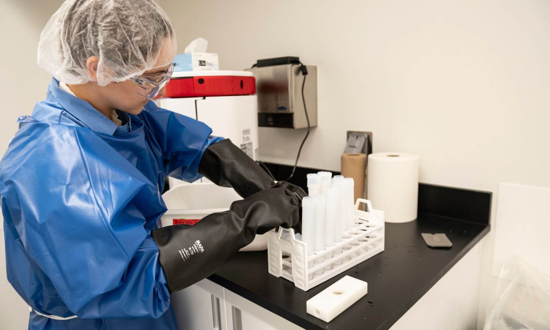 La doctorante Chloé Desjardins prépare méticuleusement son matériel de laboratoire en prévision de son analyse d'échantillons.