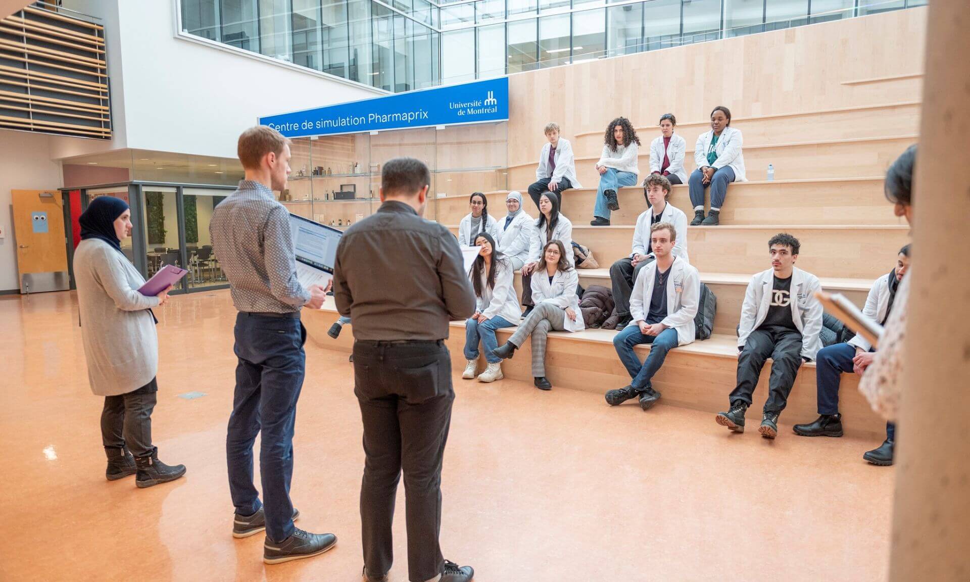 Francis Richard et Jérôme Tousignant donnent les consignes au groupe étudiant avant qu'il n'entre dans la pharmacie simulée.
