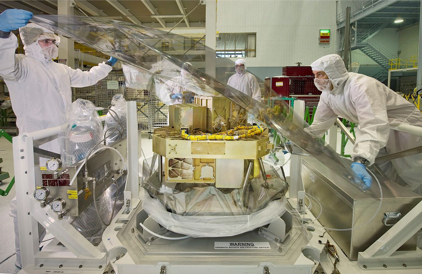 Des ingénieurs de l'Agence spatiale canadienne installent une enveloppe protectrice pour le détecteur de guidage de haute précision et le NIRISS, les deux instruments qui composent cet assemblage.