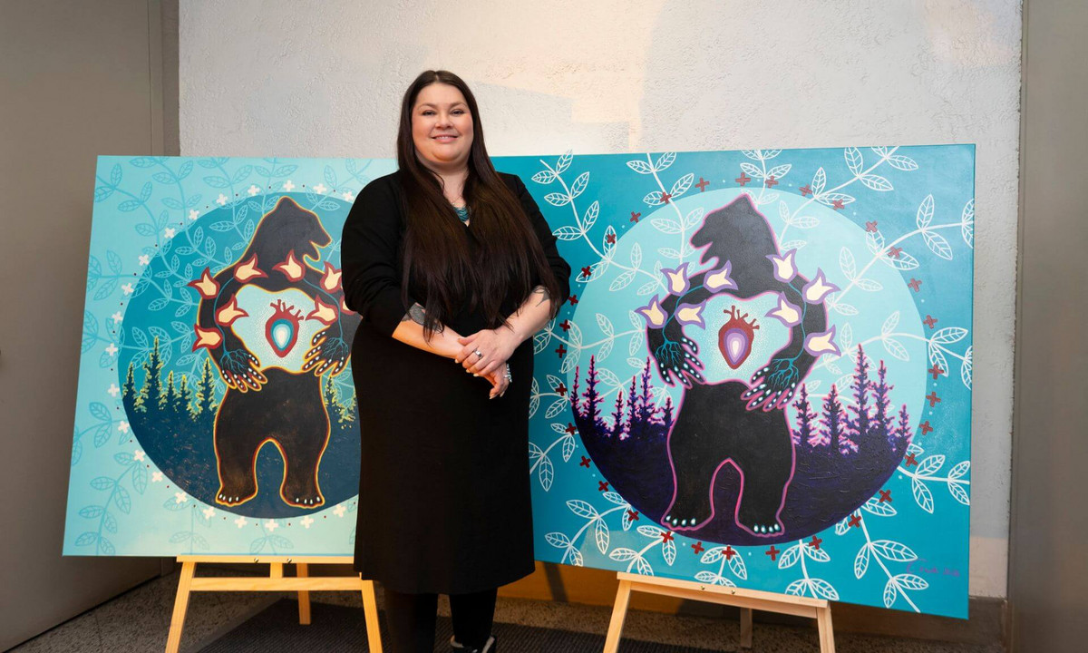 L’artiste atikamekw Eruoma Awashish devant son œuvre. 