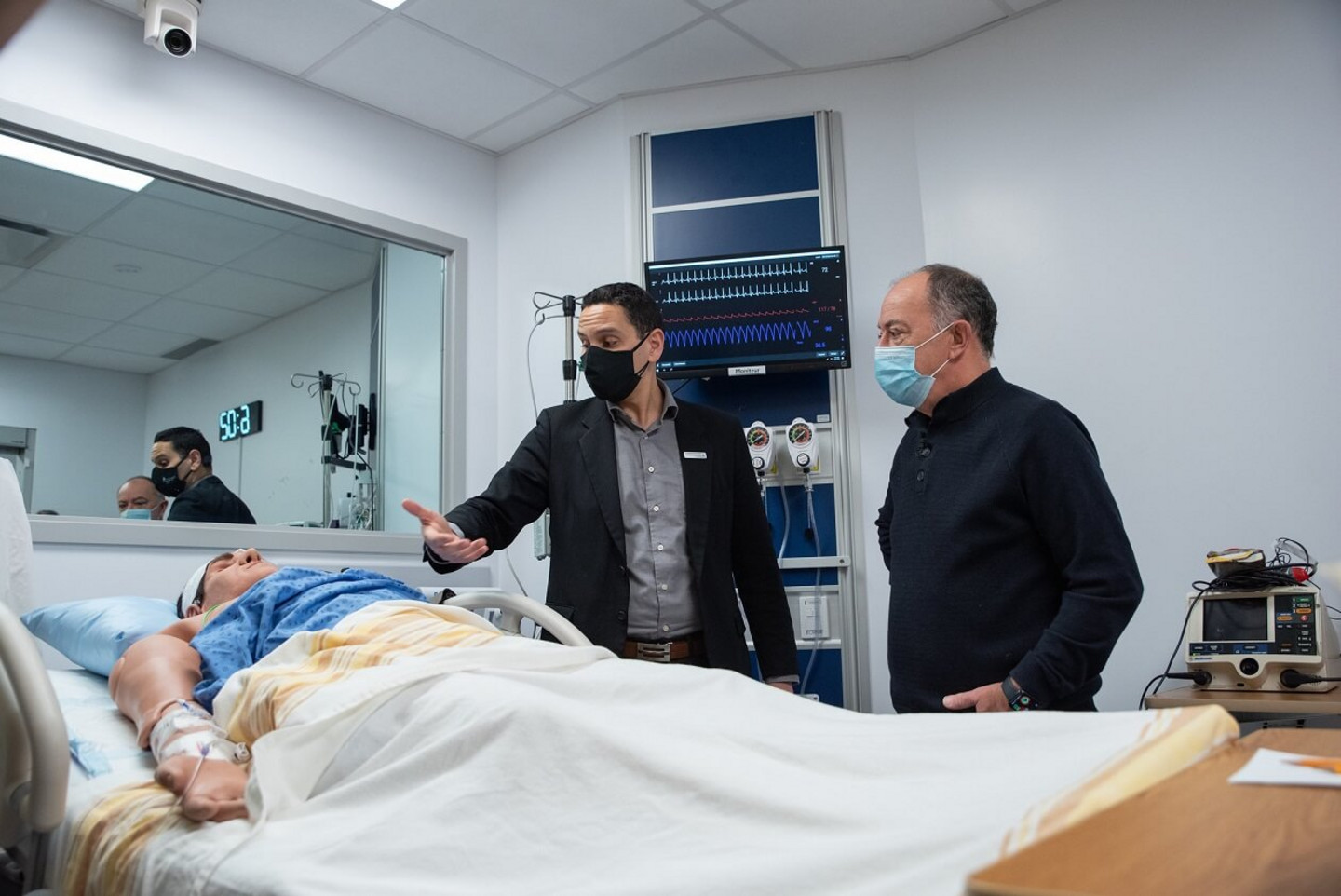 Le directeur du Centre de simulation en santé, Mohammed Abbad, explique au ministre Dubé les différentes caractéristiques des mannequins qui sont utilisés dans les activités de simulation et de formation du centre.