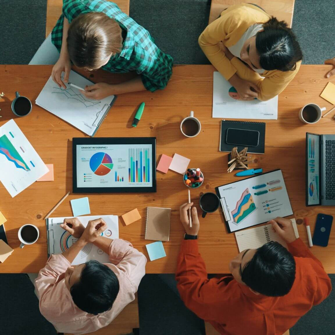 Une équipe de travail est réunie autour d'une table et de documents pour une session de travail