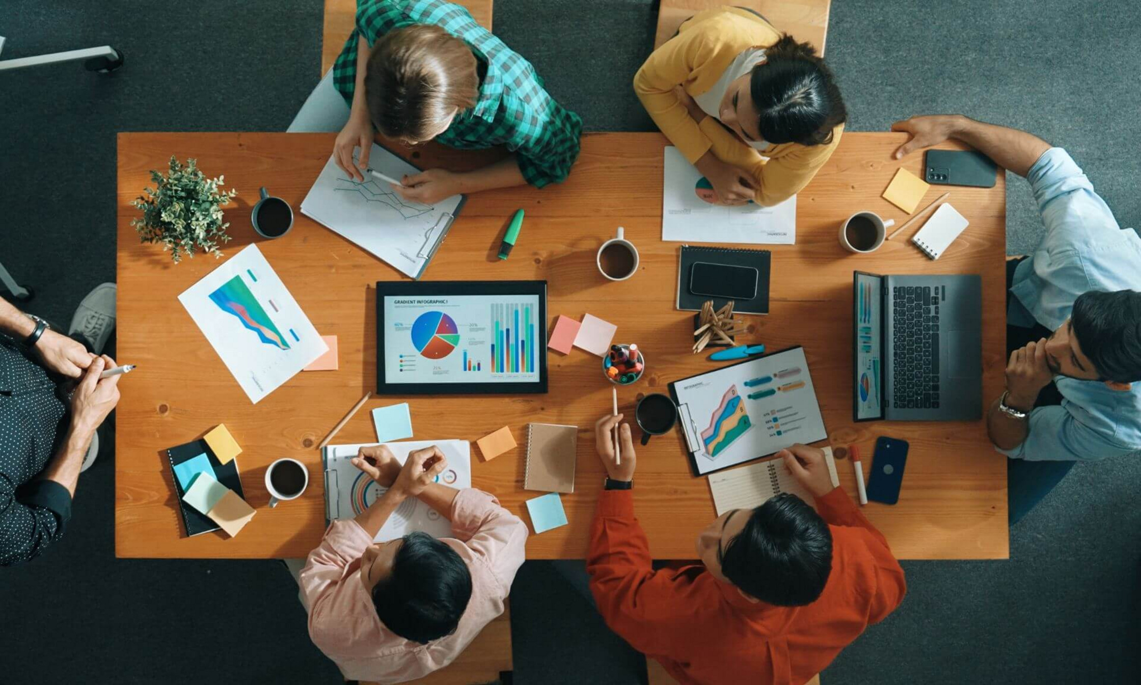 Une équipe de travail est réunie autour d'une table et de documents pour une session de travail