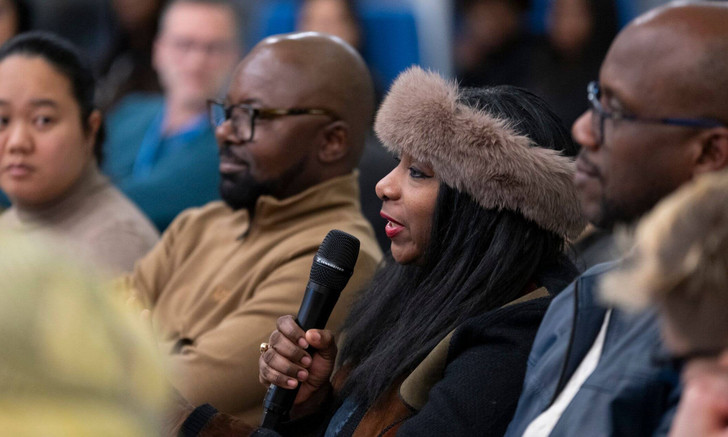 À la conférence-débat, une personne de l'auditoire prend la parole.