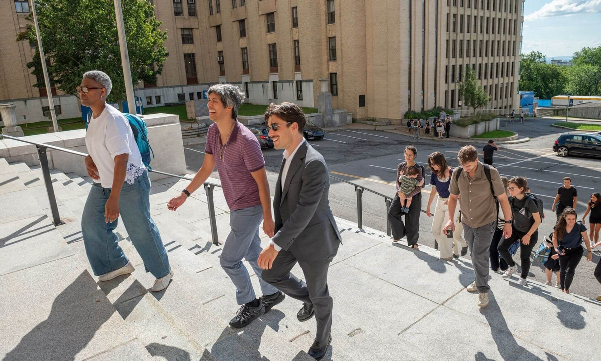 Des nouveaux professeurs gravissent les marches extérieures du pavillon Roger-Gaudry.