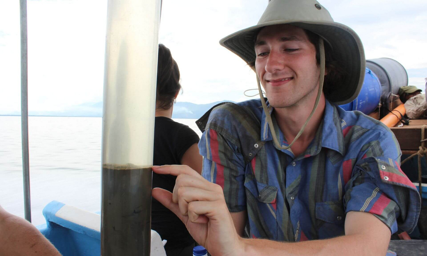 Benjamin Gwinneth observe une carotte de sédiments lacustres tirée du lac Izabal, au Guatemala.