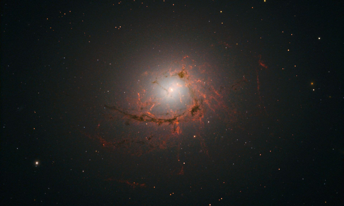 An image of elliptical galaxy NGC4696 located at the center of the Centaurus Cluster taken by the Hubble Space Telescope. This image shows dusty filaments surrounding the center of the galaxy. 