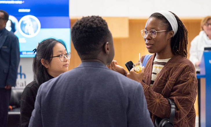 Des participantes et participants à la conférence-débat discutent avec les panélistes à la fin de la rencontre.