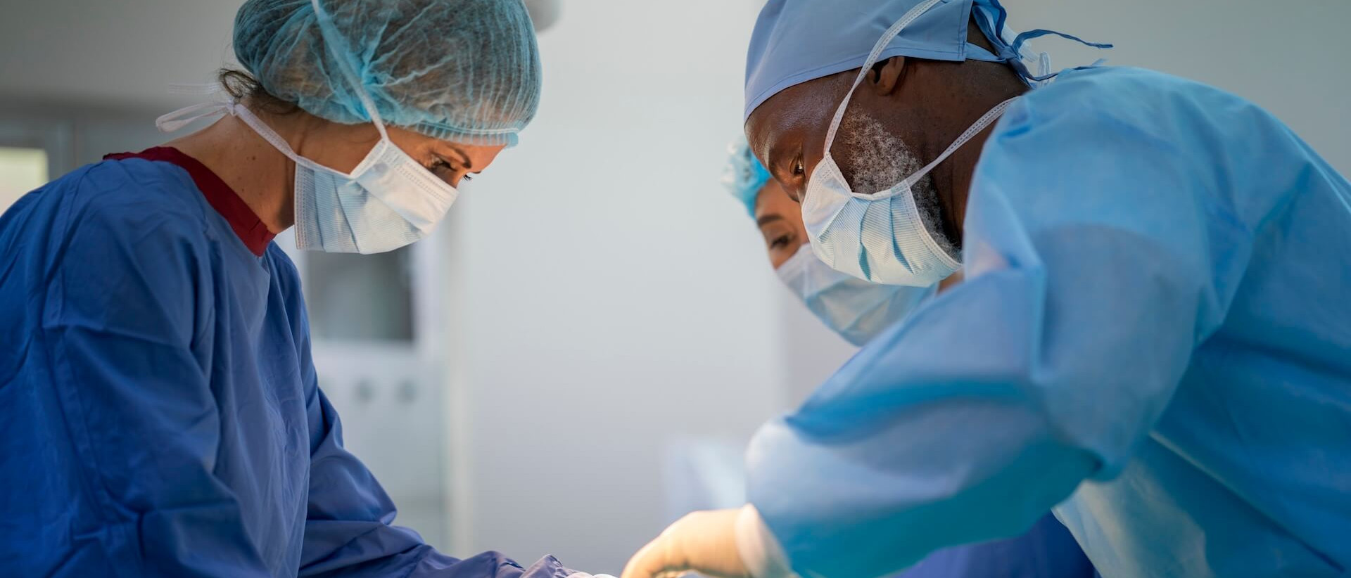 Des chirurgiens opèrent un patient aux urgences. Ils portent des blouses chirurgicales à l'hôpital.