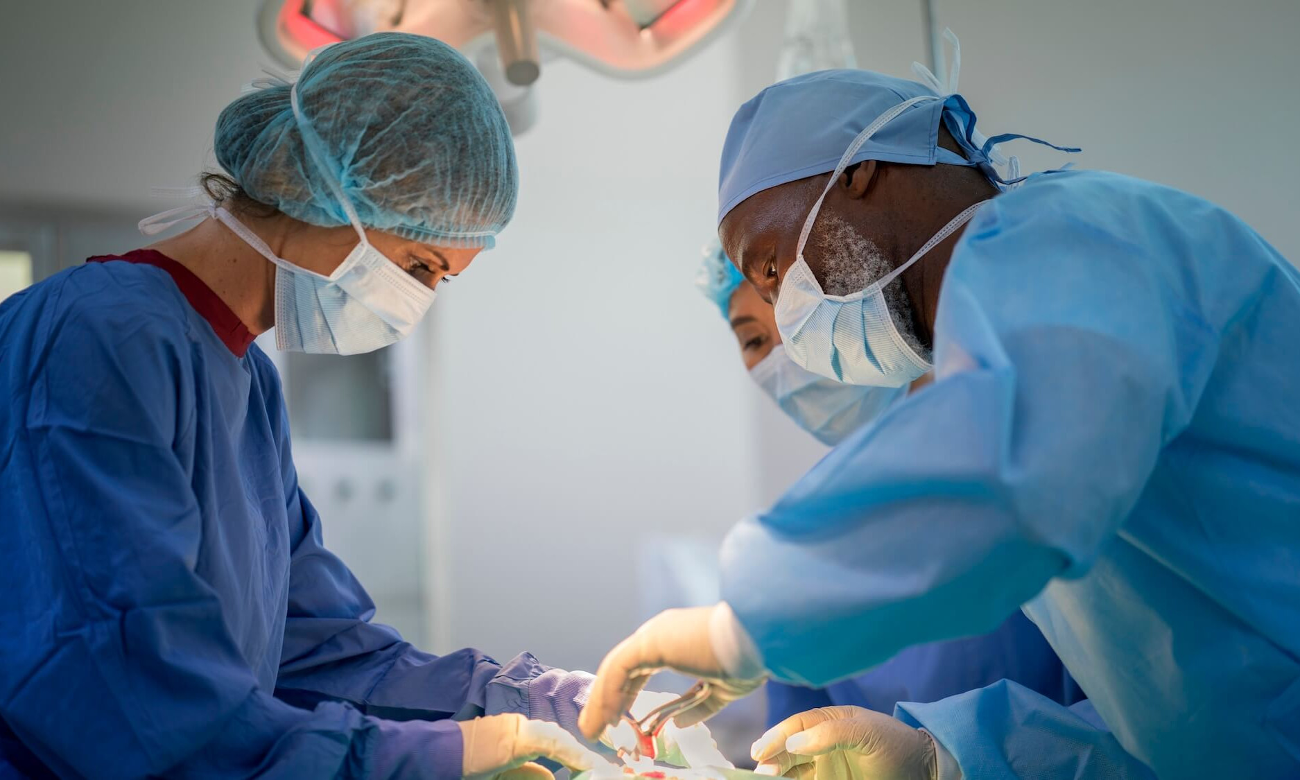 Des chirurgiens opèrent un patient aux urgences. Ils portent des blouses chirurgicales à l'hôpital.