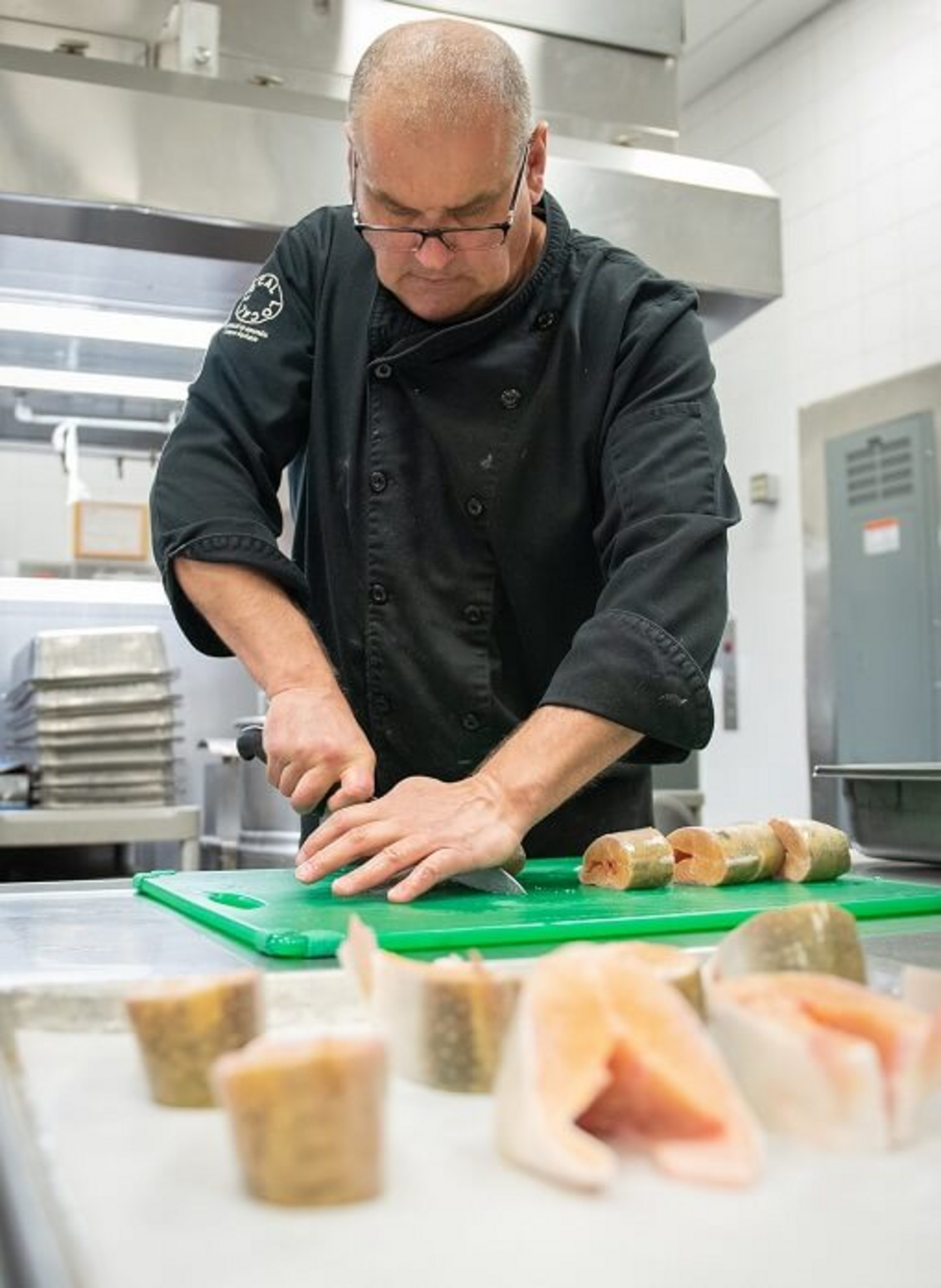 Le chef de cuisine Jean-Manuel Nabais De Marques s'affaire à couper l'omble chevalier en darnes pour le service du dîner.