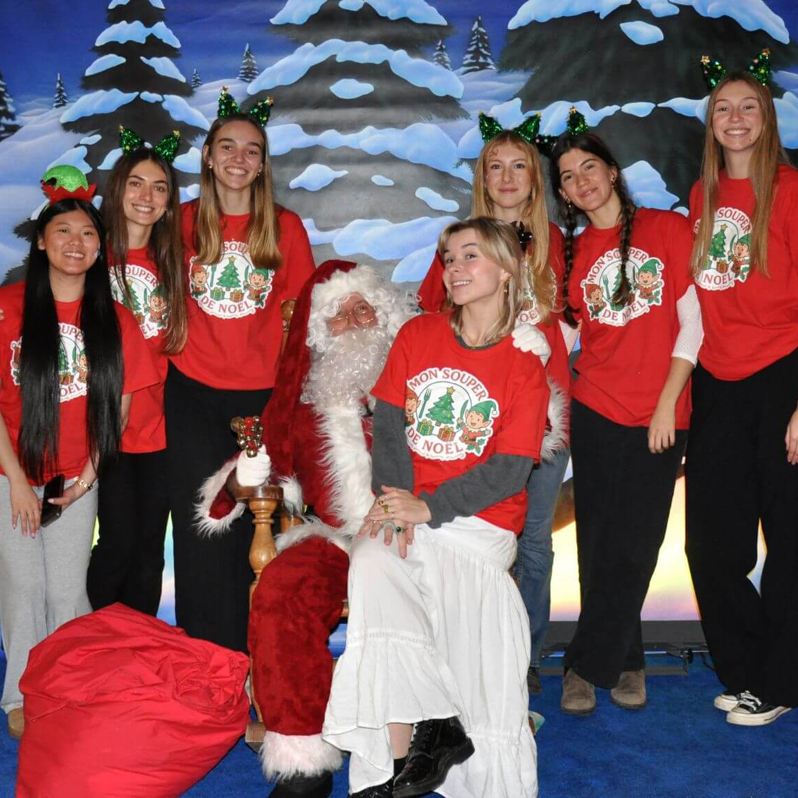 Les six organisatrices (de gauche à droite, Lara Tu-Tam Nguyen, Florence Emard, Laurie-Anne Lalonde, Coralie Marier, Léanne Poignonnec et Marianne Larose) et la bénévole Maë Beaucage avec le père Noël, présent lors du souper.