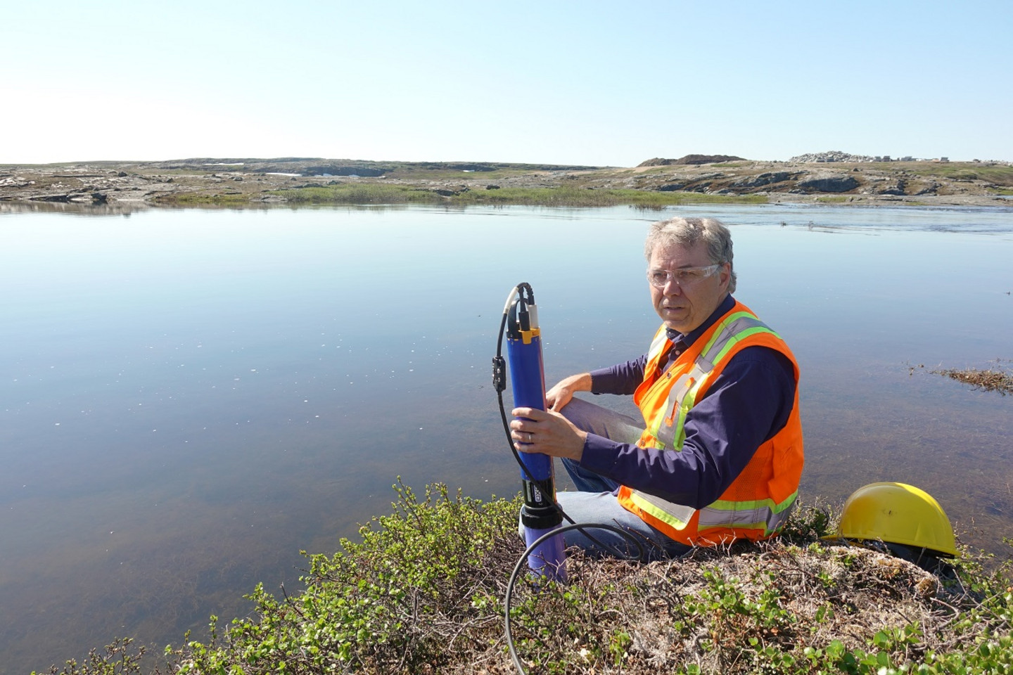 Le professeur Marc Amyot, aux abords de la rivière Innuksac, avec une sonde qui permet de mesurer les paramètre psyhico-chimiques du sol riverain.